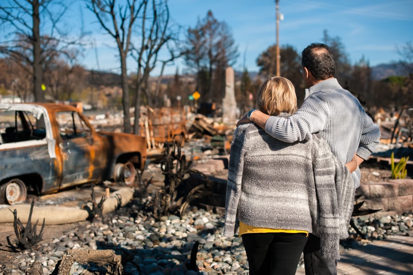 Couple checking ruins after fire disaster.